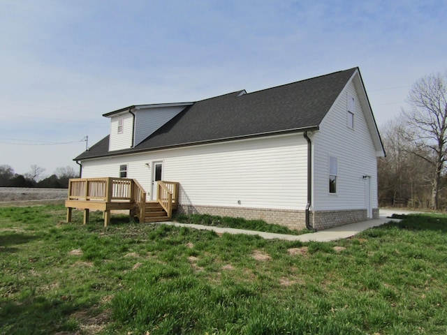 rear view of house with a wooden deck and a lawn