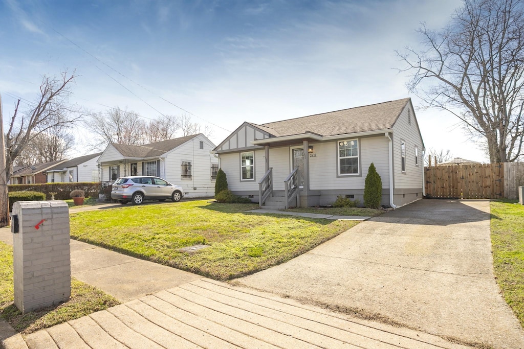 view of front of house with a front lawn, fence, roof with shingles, and crawl space