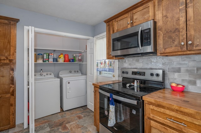 kitchen with brown cabinets, washer and clothes dryer, wood counters, tasteful backsplash, and stainless steel appliances