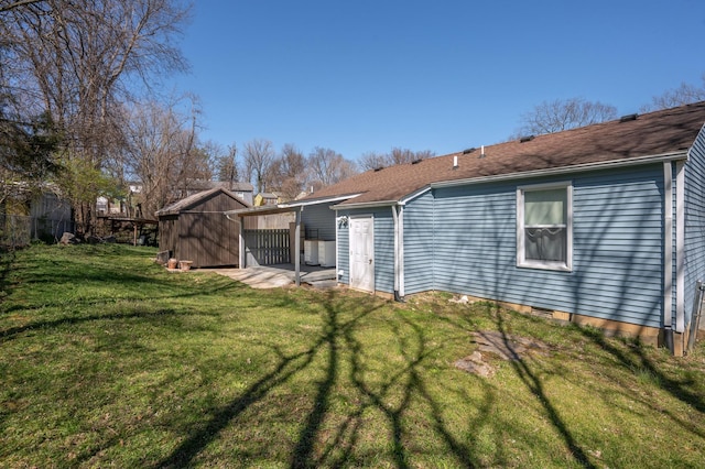 rear view of house with a lawn, an outdoor structure, and a shed