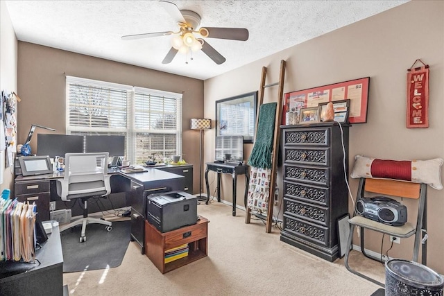 carpeted office space featuring ceiling fan, baseboards, and a textured ceiling