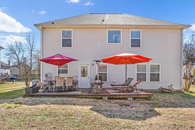 back of house with a deck and a lawn