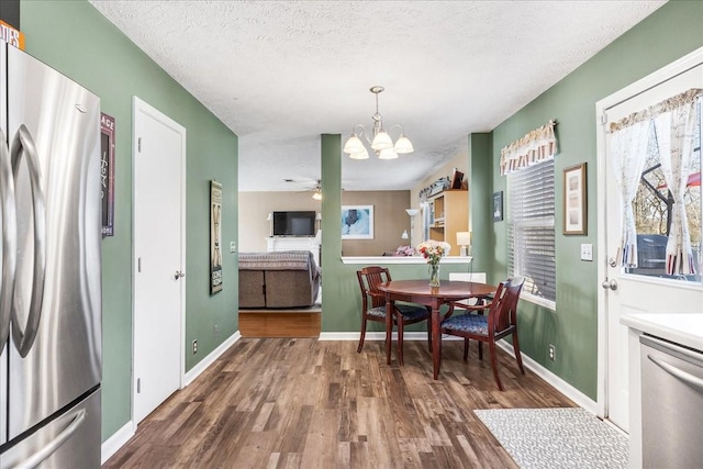 dining area with wood finished floors, baseboards, and a textured ceiling