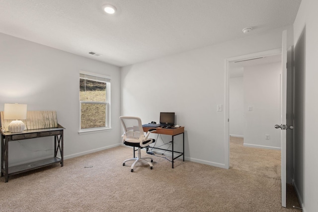 carpeted office space featuring baseboards and visible vents