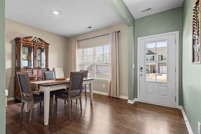 dining area with dark wood-type flooring, baseboards, and visible vents