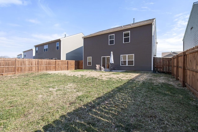 rear view of property with a yard, a fenced backyard, and a patio area