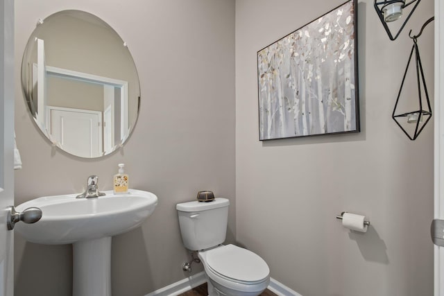 bathroom featuring toilet and baseboards