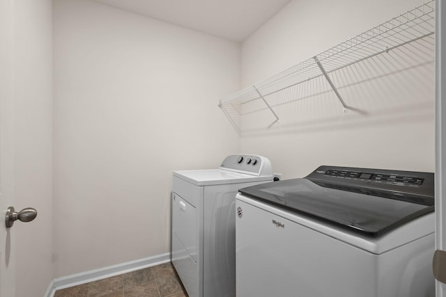 washroom with laundry area, baseboards, and washing machine and clothes dryer