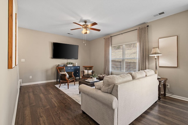 living room featuring a ceiling fan, dark wood-style floors, and visible vents