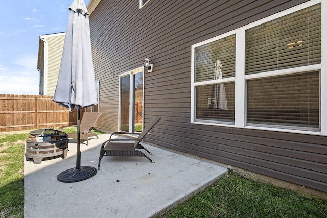 view of patio with an outdoor fire pit and fence