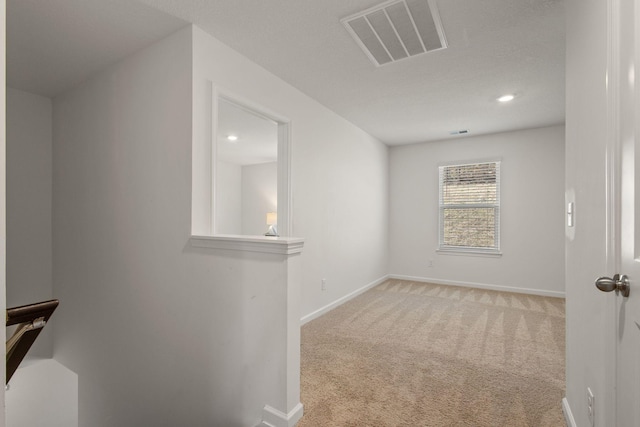 spare room featuring recessed lighting, carpet, visible vents, and baseboards