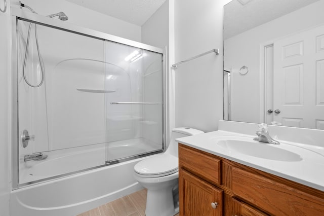 full bathroom with vanity, toilet, shower / bath combination with glass door, and a textured ceiling