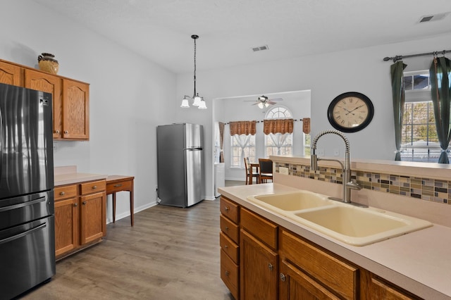 kitchen with visible vents, light countertops, freestanding refrigerator, and a sink