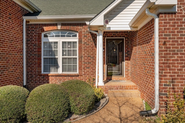 view of exterior entry with brick siding