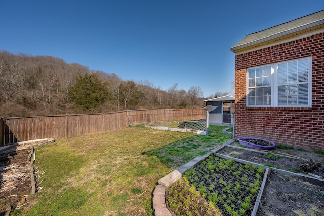 view of yard with a fenced backyard and a garden