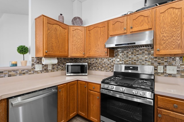 kitchen with ventilation hood, light countertops, decorative backsplash, brown cabinetry, and stainless steel appliances