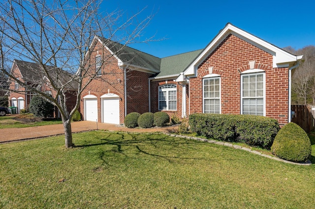 view of front of house with brick siding, driveway, a front lawn, and fence