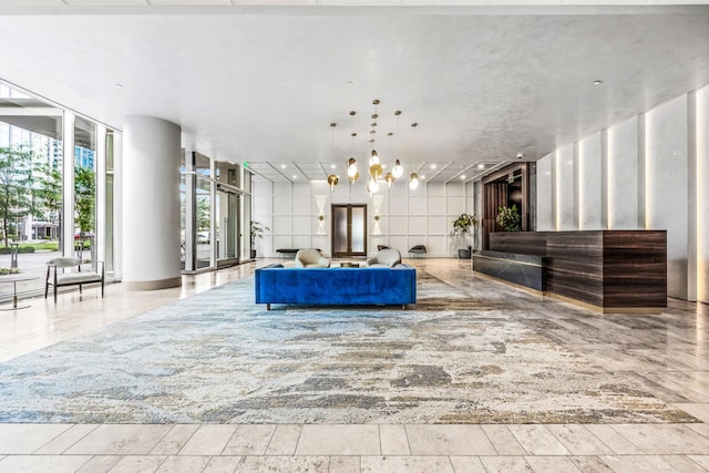 living area with floor to ceiling windows and a notable chandelier