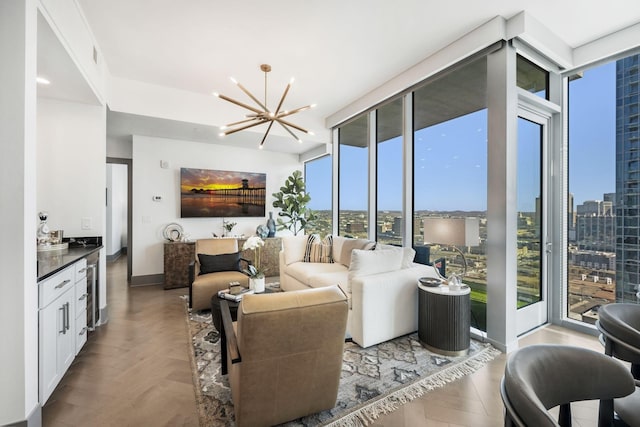 living room with a notable chandelier, a city view, beverage cooler, a wall of windows, and baseboards