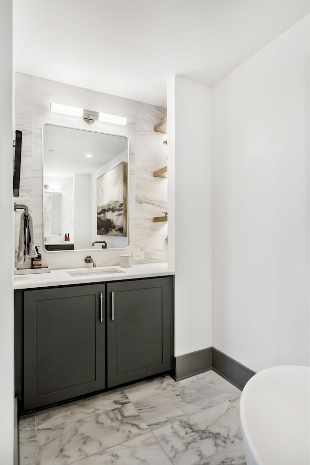 bathroom with vanity, baseboards, and marble finish floor