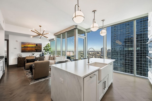 kitchen with pendant lighting, expansive windows, white cabinets, light countertops, and a chandelier