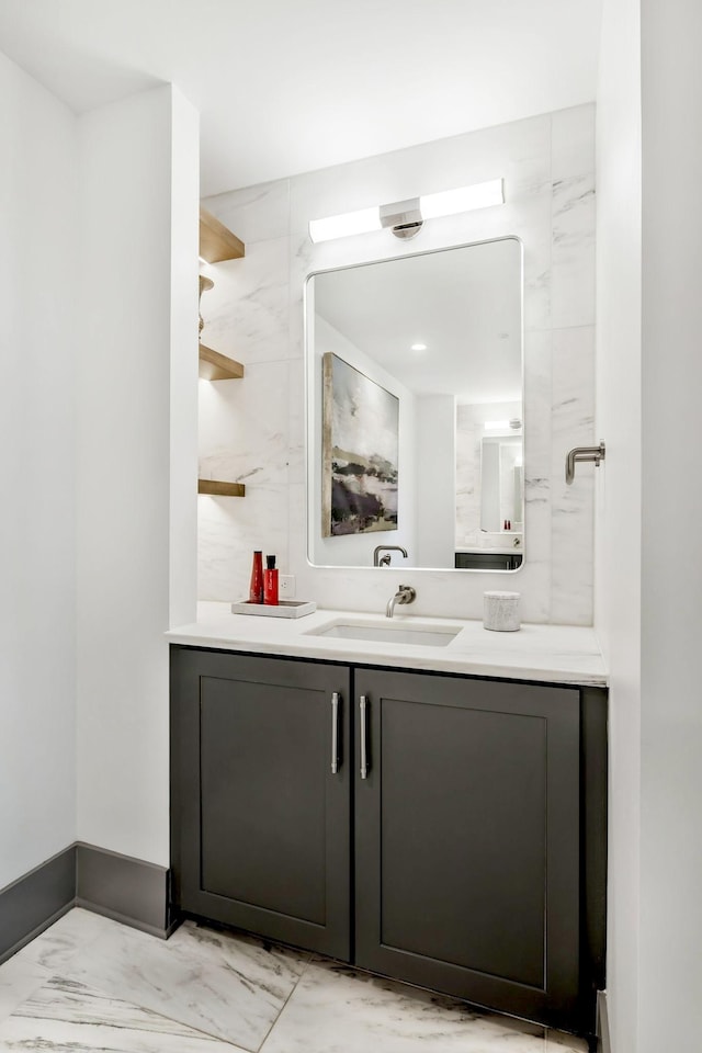 bathroom with vanity, baseboards, and marble finish floor