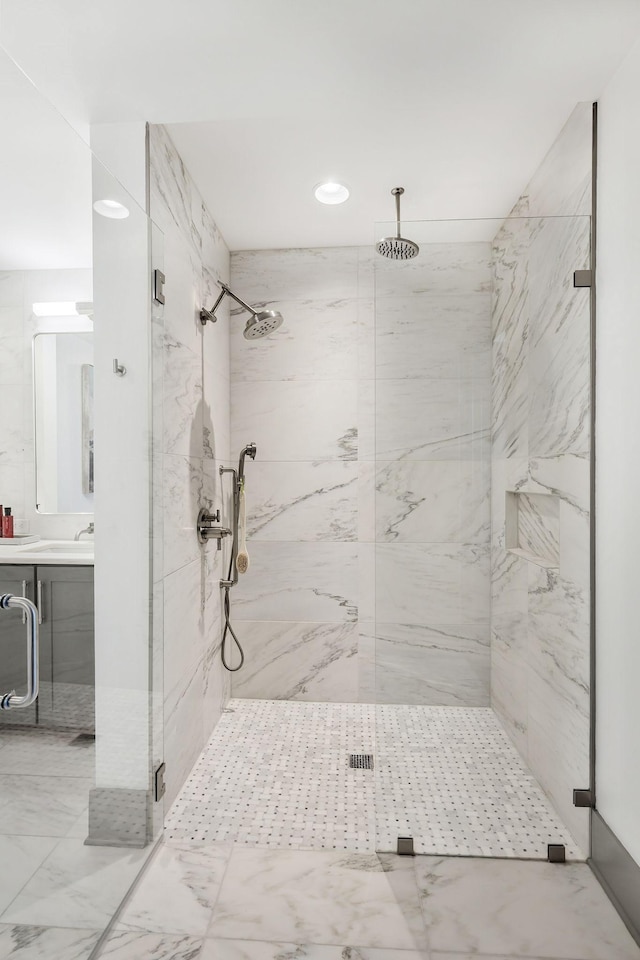 bathroom with a marble finish shower and vanity