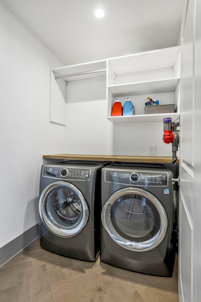 laundry room featuring laundry area, baseboards, and washing machine and clothes dryer