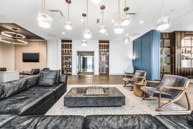 living area with visible vents, baseboards, and wood finished floors