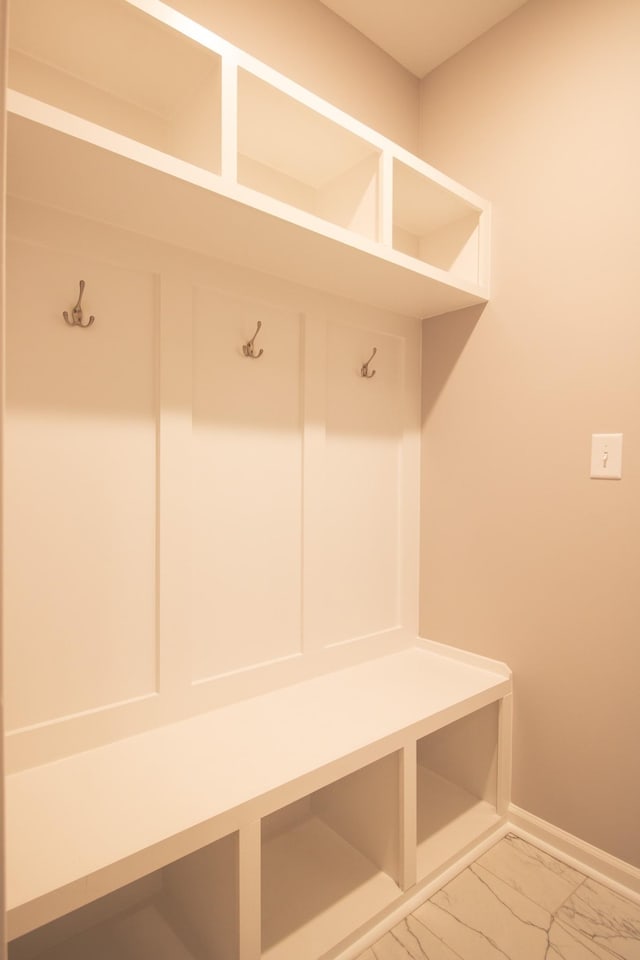 mudroom with marble finish floor and baseboards