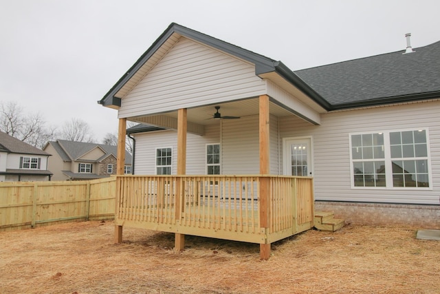 rear view of property featuring a deck, roof with shingles, ceiling fan, and fence