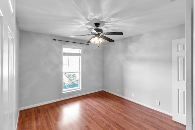 spare room featuring baseboards, a ceiling fan, and wood finished floors