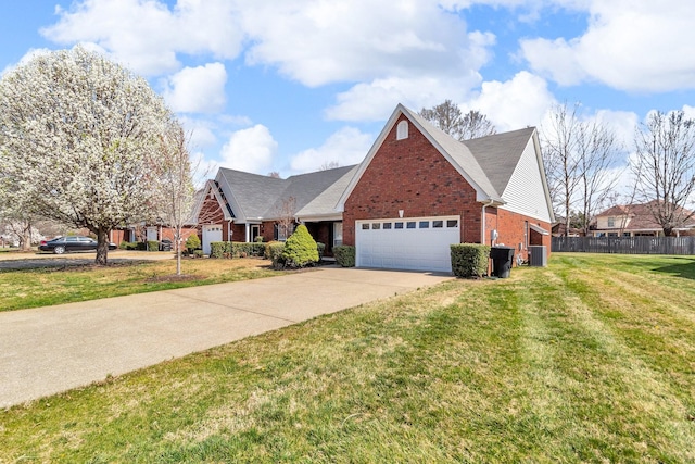 traditional-style home with concrete driveway, a front lawn, an attached garage, brick siding, and fence