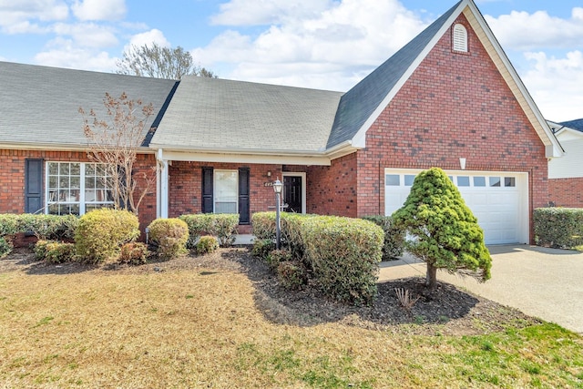 view of front of house with a shingled roof, a garage, a front yard, and brick siding