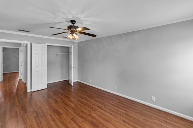 unfurnished bedroom with crown molding, visible vents, baseboards, and wood finished floors