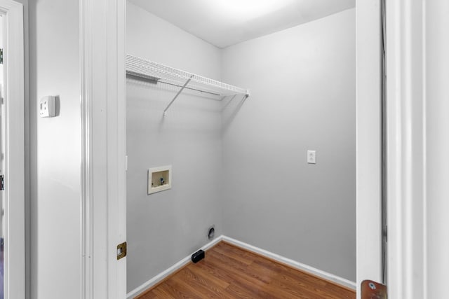 laundry area featuring baseboards, wood finished floors, laundry area, and washer hookup
