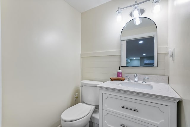 half bathroom with toilet and vanity