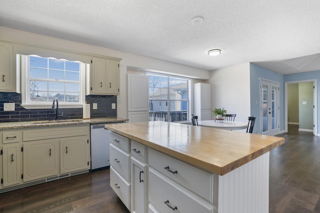 kitchen featuring dishwasher, butcher block counters, dark wood finished floors, and a sink