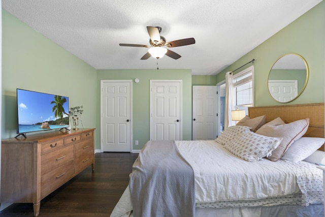 bedroom with ceiling fan, baseboards, a textured ceiling, and dark wood-style floors