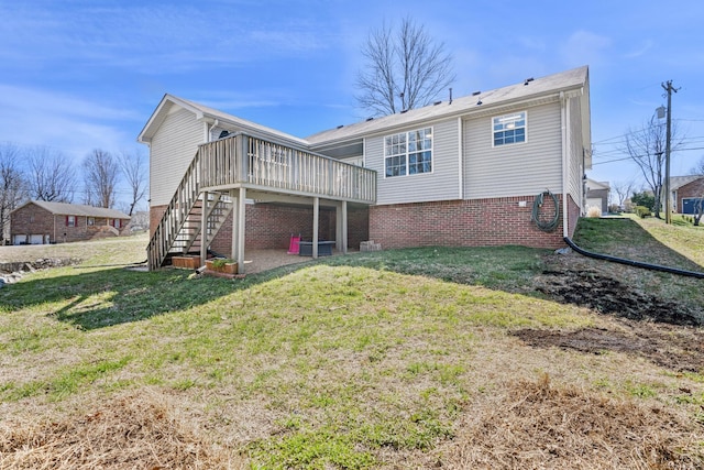 rear view of property with a yard, brick siding, a wooden deck, and stairway