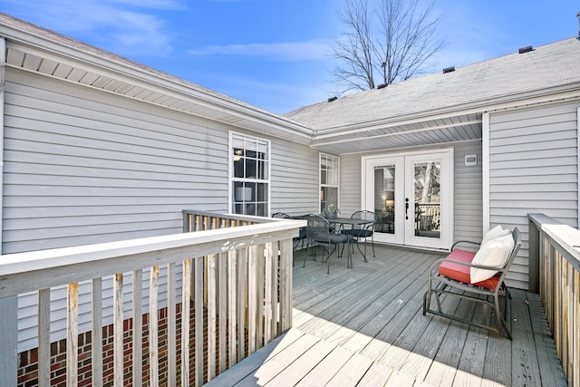 wooden terrace featuring french doors and outdoor dining area