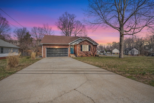 view of front of home featuring a garage, a front lawn, brick siding, and driveway