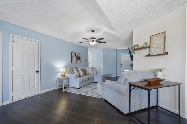 living room featuring ceiling fan, a textured ceiling, baseboards, and wood finished floors