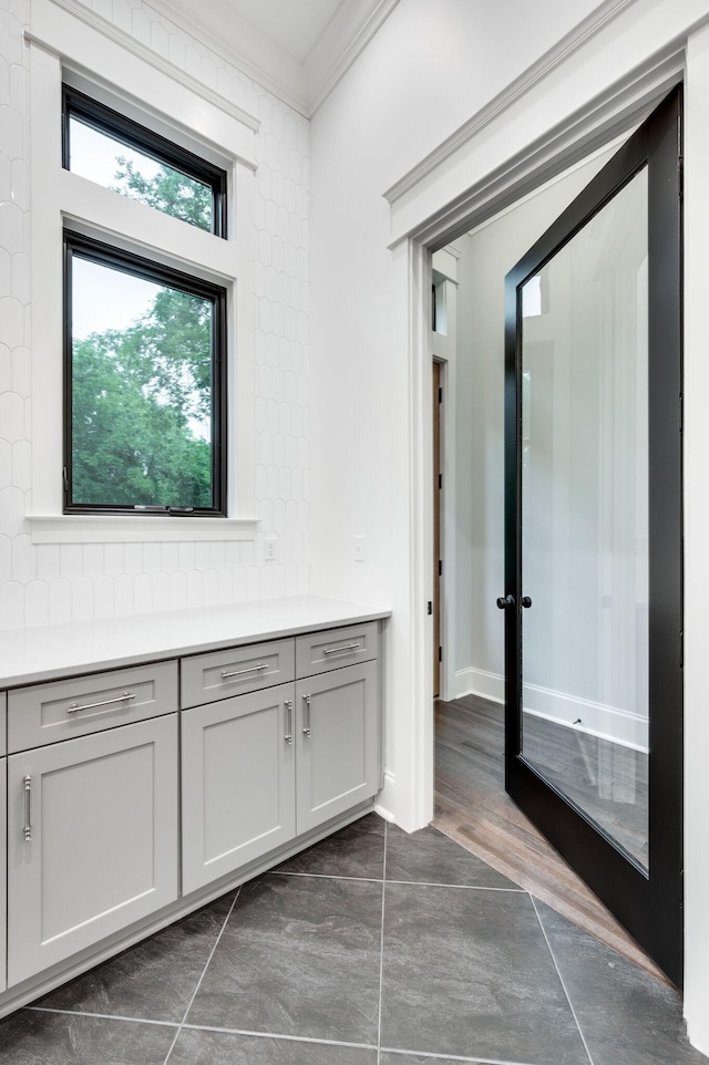 bathroom with baseboards, tasteful backsplash, and ornamental molding