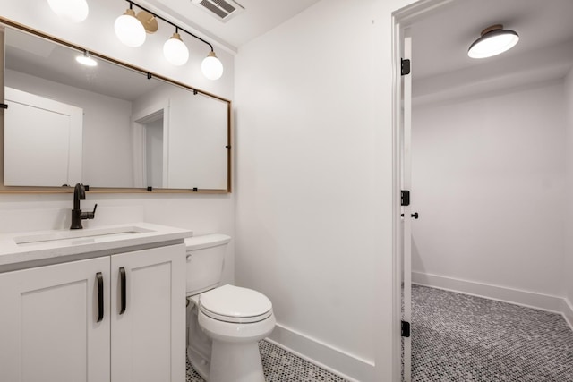 bathroom featuring visible vents, baseboards, toilet, and vanity