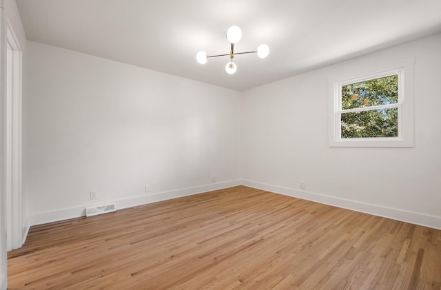 spare room featuring visible vents, baseboards, and light wood finished floors