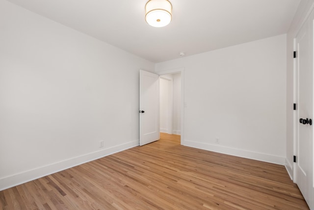 empty room featuring light wood-style flooring and baseboards