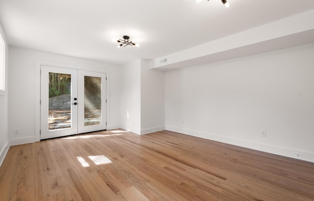 spare room featuring french doors, baseboards, visible vents, and wood finished floors