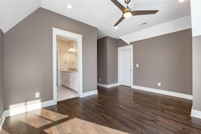 unfurnished bedroom with baseboards, wood finished floors, and vaulted ceiling