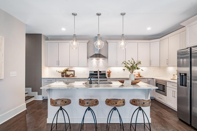 kitchen with a sink, tasteful backsplash, appliances with stainless steel finishes, and dark wood-style flooring